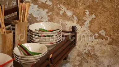 带有东方餐具的架子。 木制架子，有各种亚洲餐具，挂在厨房破壁附近。